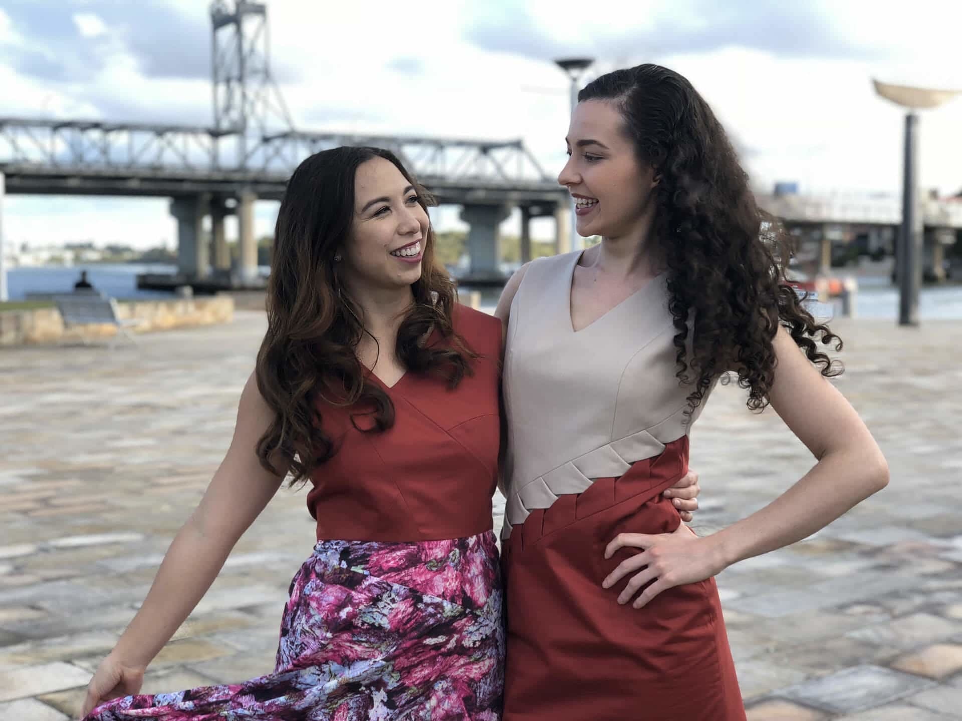 Two women looking stylish and standing arm in arm