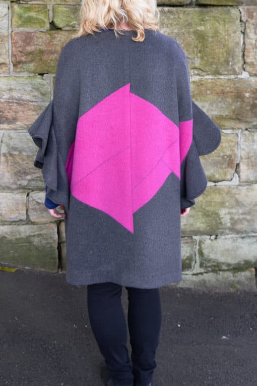 Rear view of grey and pink flutter sleeve poncho