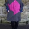 Front image of grey and pink flutter sleeve poncho